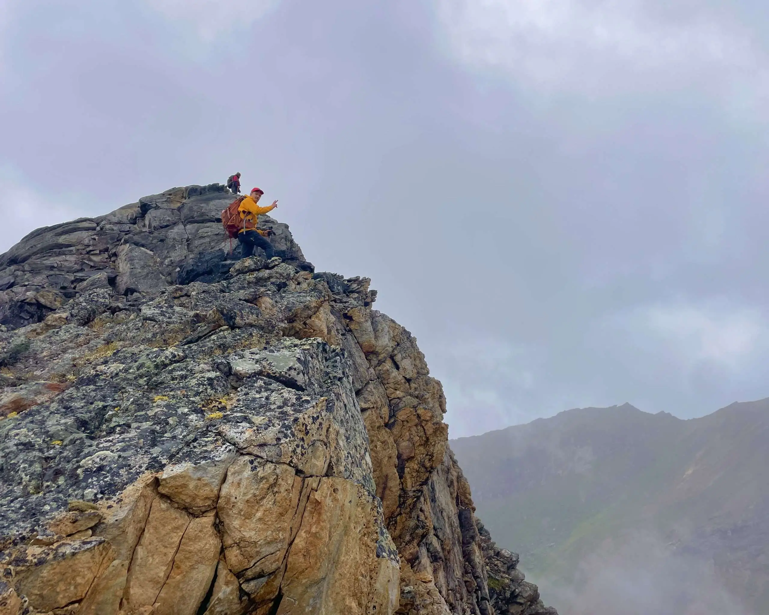 Image of man on top of mountain summit with clouds