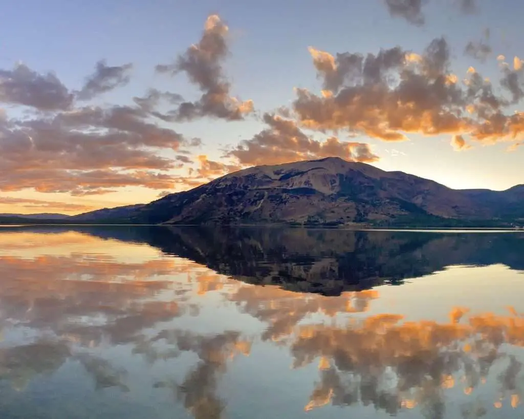 Image of orange sunset with mountain reflected on lake water